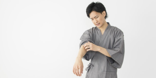 かゆい個所をかく男性