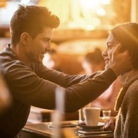 Affectionate man sitting in a cafe with his girlfriend and expressing his love on a romantic way.