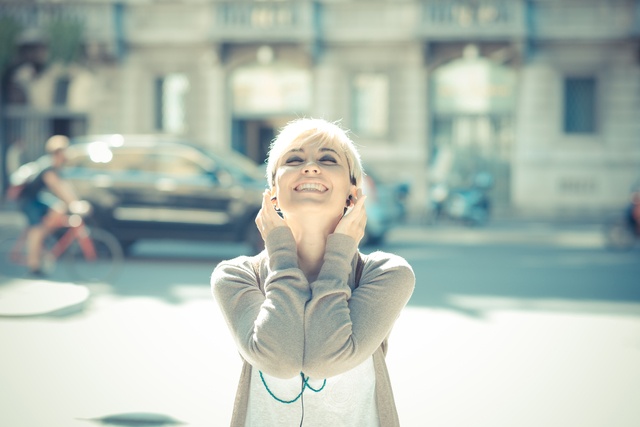 beautiful young blonde short hair hipster woman listening music