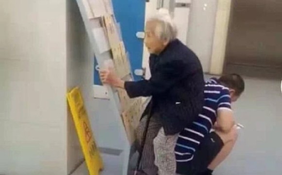 病院の待合室は込み合っており空席がなかった。息子は84歳の母親の為に椅子になった（中国）