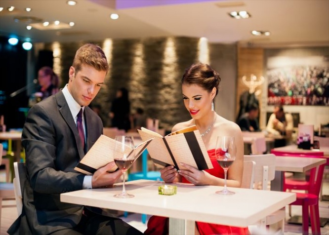 young happy couple in restaurant reading menu