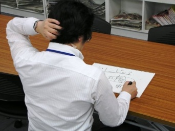 作成に挑むJタウンネット記者。肩の湿布がめくれている。