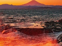 オレンジ色の波と空、そして富士山　夕暮れに染まる風景が切なく力強い