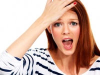 Portrait of a young woman with her hand on her forehead in a moment of realisation - Isolated