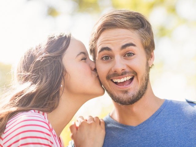 男性の頬にキスする女性