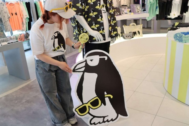 グラニフ東京・店長の佐藤愛（かな）さん、頭にシティボーイペンギンとおそろいのサングラスが...