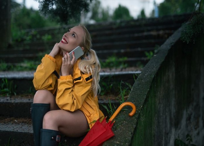 Girl sitting on a stairs and talking on a mobile phone.