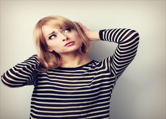 Annoyed unhappy thinking young woman looking up. Toned color portrait