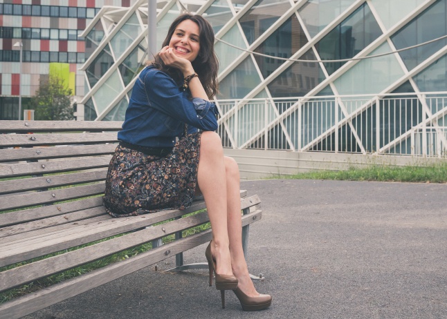 Pretty girl sitting on a bench in the street