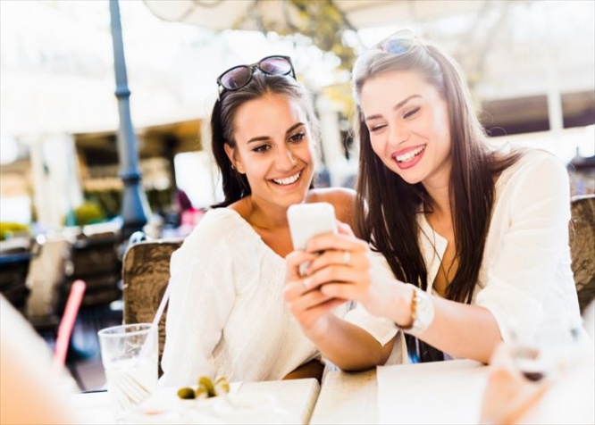 Two young girls talking and smiling during lunch break