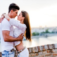 Young romantic couple hugging and about to kiss in beautiful sunset