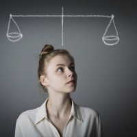 Young slim woman is full of doubts and hesitation. Scale.