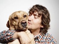 Closeup portrait handsome young hipster man, kissing his good friend dog isolated black grey background. Positive human emotions, facial expression, feelings.