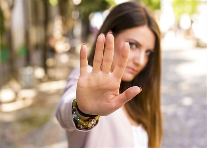 Woman with her hand extended signaling to stop. Negative human emotion. Body language. Keep the distance