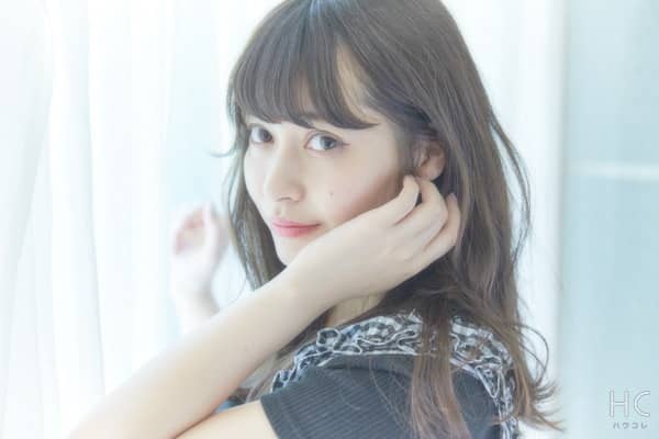 頬に手を当てて微笑む女性