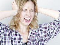 Young woman holding her head looking pained and upset