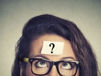 thinking woman with question mark on gray wall background