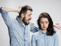 The young couple with different emotions during conflict on gray background