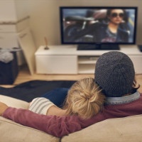 Rear view shot of a young couple watching TV together
