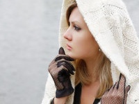 The thoughtful girl in  knitted dress on a background of water