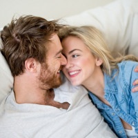 Loving couple relaxing at home lying on the sofa - relationship concepts