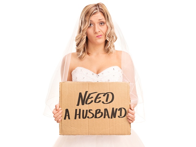 Bride holding a sign that says need a husband