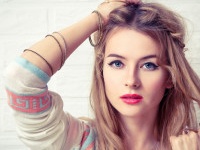 Boho Girl Portrait at White Brick Wall Background. Bohemian Fashion Woman Portrait. Toned Photo with Copy Space.