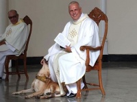 聖職者が好きすぎる犬。ミサの最中に壇上に上がり神父さんの足元でジャレジャレ（ブラジル）