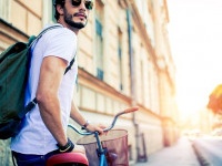 Handsome Man sitting on his Vintage Bike.Hipster bike rides by city.Hipster exploring the city by bike.