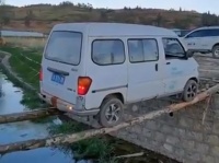 正気の沙汰かよ！細い丸太2本を川にかけ、バックで渡る車