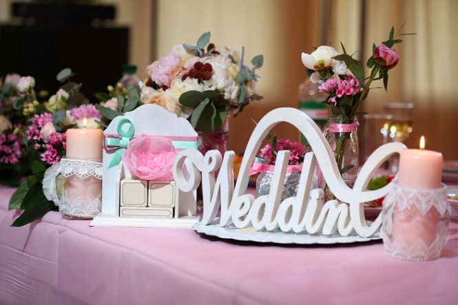 Decor wedding ceremony word wedding on the bank on the background of flowers and candle