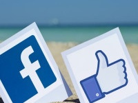 KIEV, UKRAINE - AUGUST 10, 2015: Facebook like logos for e-business, web sites, mobile applications, banners, printed on paper and placed in the sand against the sea Social network facebook sign.