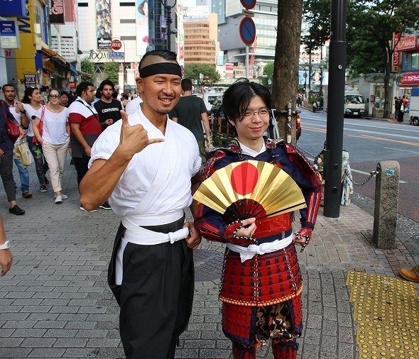 旅行者に囲まれる竹村さんとT編集長