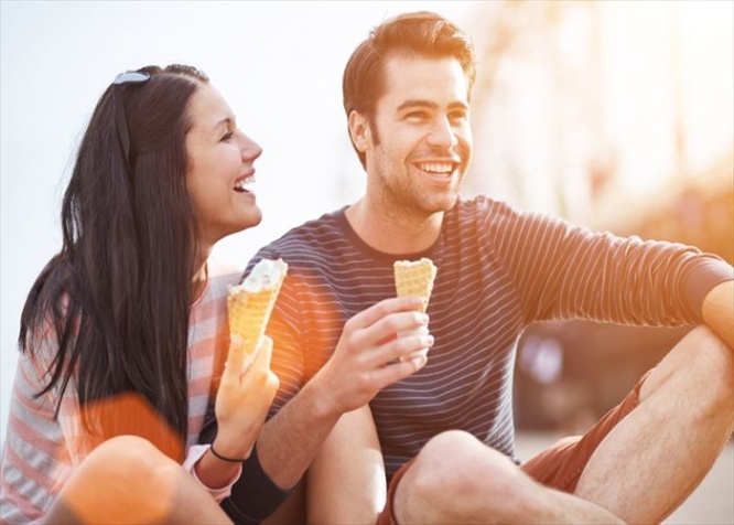 romantic couple eating ice cream at park