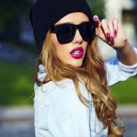 High fashion look.glamor lifestyle blond woman girl  model in casual jeans shorts cloth  outdoors in the street in black cap  in glasses