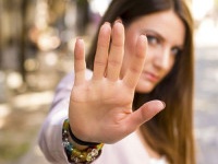 Woman with her hand extended signaling to stop. Negative human emotion. Body language. Keep the distance