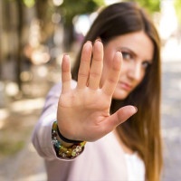 Woman with her hand extended signaling to stop. Negative human emotion. Body language. Keep the distance