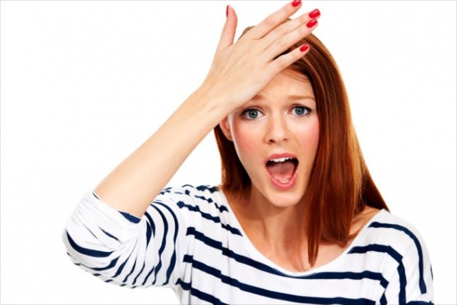 Portrait of a young woman with her hand on her forehead in a moment of realisation - Isolated