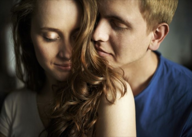 Young man enjoying smell of hair of his sweetheart