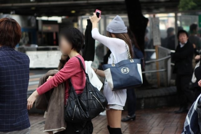 着ていたセーターを脱ぐ女性