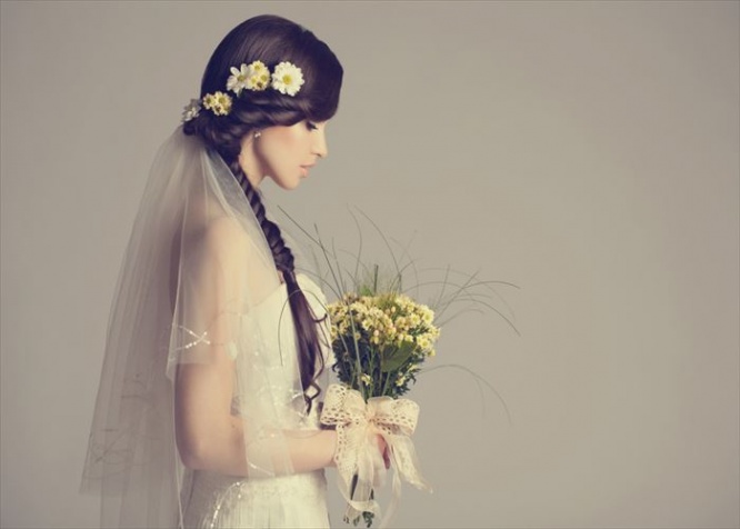 Studio shot of young beautiful bride on light background. Professional make up and hair style.