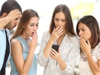 Four worried friends watching smart phone