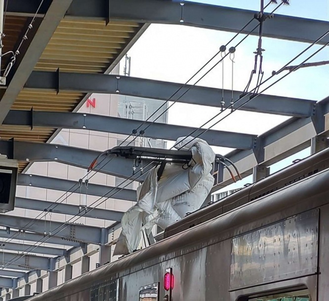 パンタグラフに引っかかる布団（画像提供：真塚なつき（＠truetomb）さん）