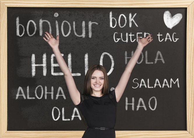 Woman near words hello in different languages on chalkboard