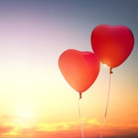 two red balloons in shape of heart on the background of sunset sky. the concept of love and Valentine's day.