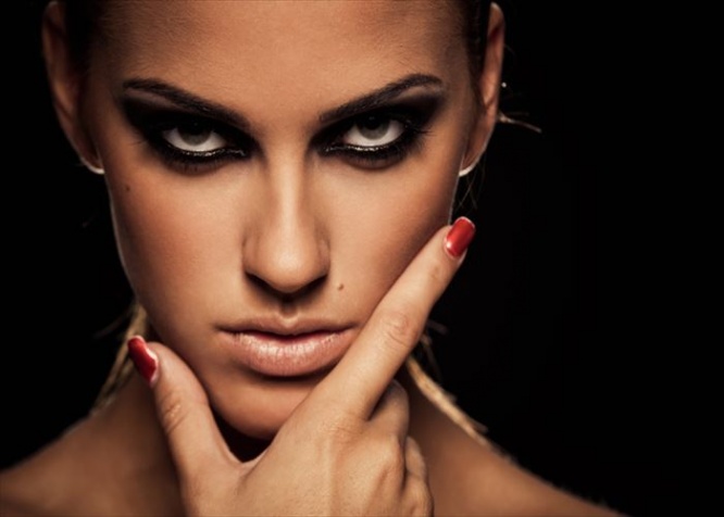 Closeup portrait of a serious lady with smoky eye makeup