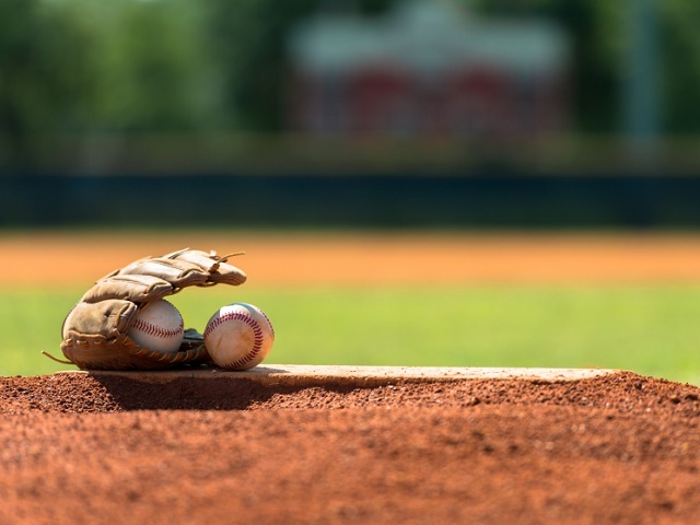 Baseball mitt and baseballs on pitchers mound