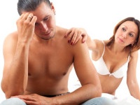 Sad middle-aged man has problem, a wife comforting him in bed at bedroom