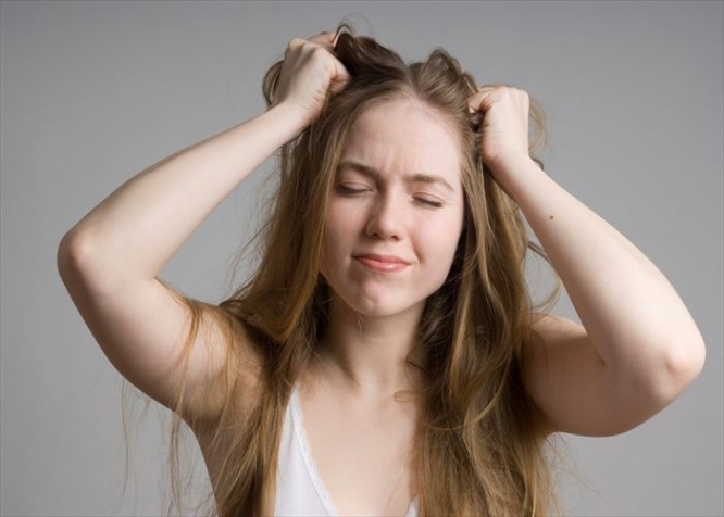 Stress and frustrated woman with hands in her long hair pulling.