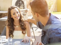 Young couple talking on the terrace of the restaurant, while eating